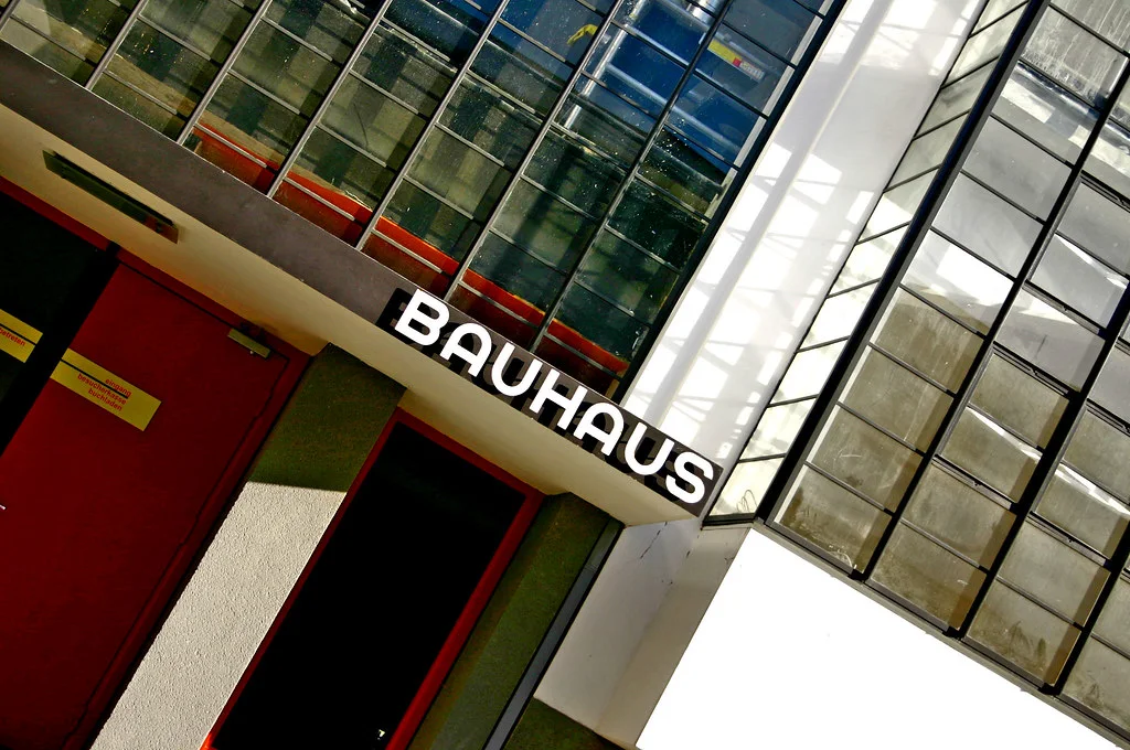 Bauhaus Dessau: A modernist complex with glass curtain walls, flat planes, long lines, and connected volumes.