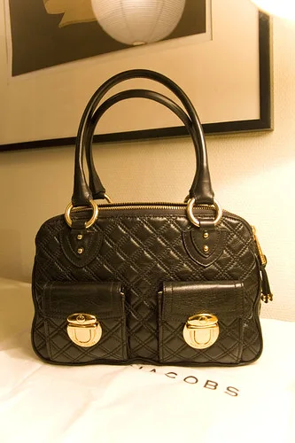 Quilted Chain Shoulder Bag: A compact bag with a quilted surface, chain strap, flap or zip closure, and metal details.